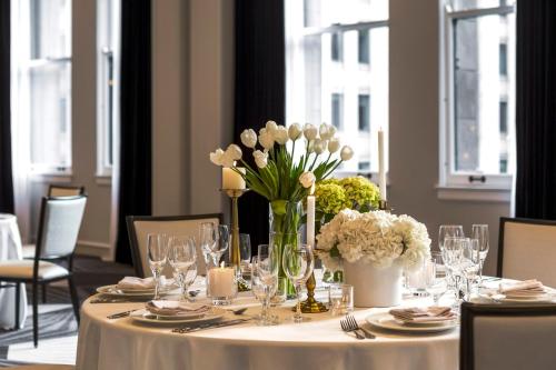 a table with a vase of white flowers on it at Kimpton Gray Hotel Chicago by IHG in Chicago