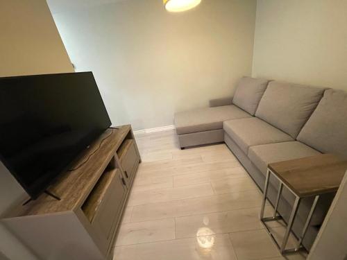 a living room with a couch and a flat screen tv at Le Convivial in Rouyn