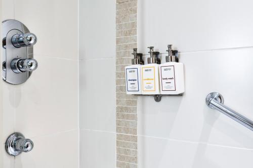 a bathroom with two bottles ofodorizers in a shower at Park Inn by Radisson Cardiff City Centre in Cardiff