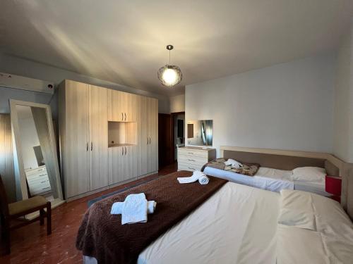 um quarto com uma cama grande e toalhas em Bujtina Shqiptare em Tirana