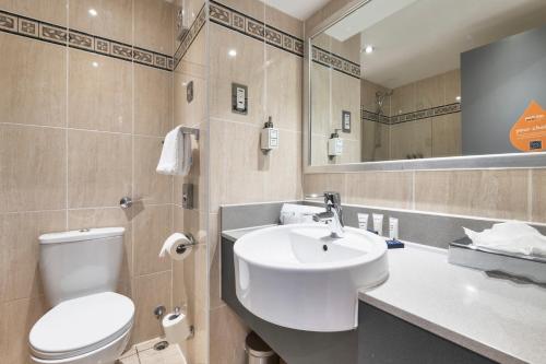 a bathroom with a white toilet and a sink at Park Inn by Radisson Cardiff City Centre in Cardiff