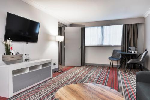 a living room with a flat screen tv on a wall at Park Inn by Radisson Cardiff City Centre in Cardiff