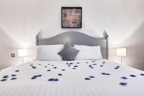 a white bed with blue flower petals on it at Park Inn by Radisson Cardiff City Centre in Cardiff