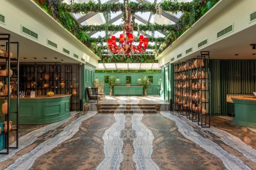 a library with bookshelves and a chandelier at Tomis Garden Aparthotel Bucuresti in Bucharest