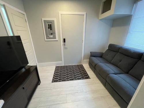 a living room with a blue couch and a door at Le Convivial in Rouyn