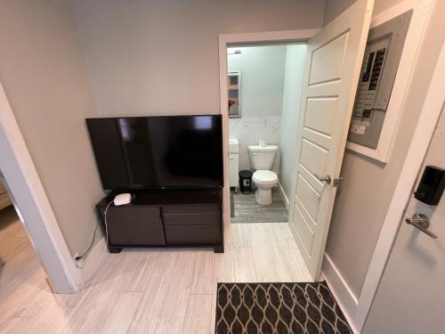 baño con TV grande y aseo en Le Convivial, en Rouyn