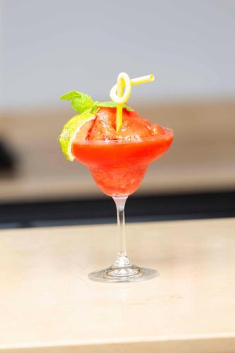 a drink in a glass on a table at Roots Hotel Apartment in Accra