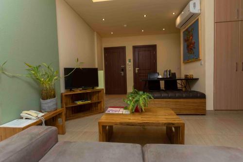 a living room with a couch and a tv at Roots Hotel Apartment in Accra
