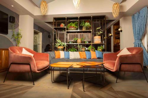a living room with a couch and two chairs at Roots Hotel Apartment in Accra