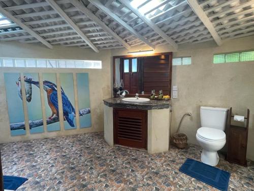 Rockside Cabanas Hotel في يوناواتونا: حمام مع مرحاض ومغسلة