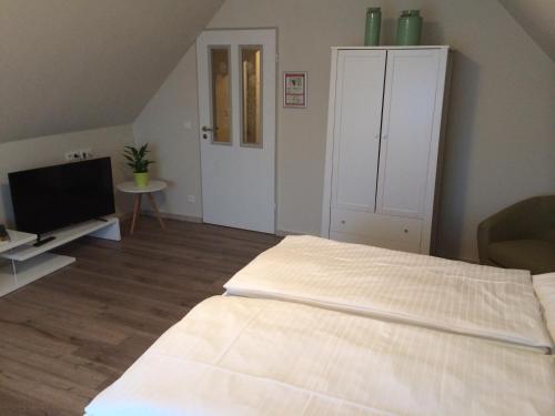 a bedroom with a bed and a flat screen tv at Hotel Restaurant Am Kring in Vreden