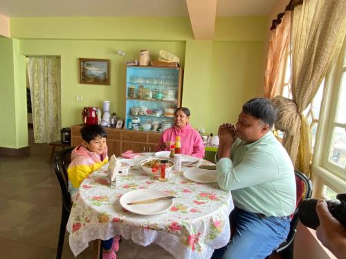 a group of people sitting around a table at Syangden Villa, Nagbeli BNB in Darjeeling