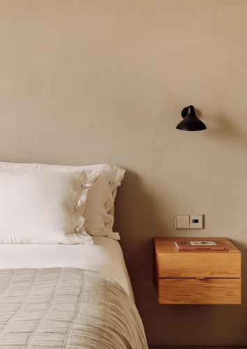 a bedroom with a bed with a night stand and a lamp at Pa.te.os in Melides