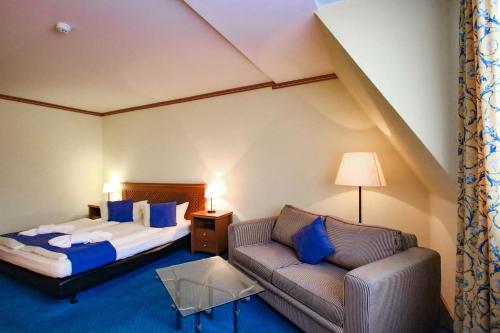 ein Hotelzimmer mit einem Bett und einem Sofa in der Unterkunft Gasthaus Zum Schwan in Oschatz