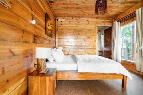 a bedroom with a bed in a wooden cabin at Peraja Bungalows Loyok in Sangyang