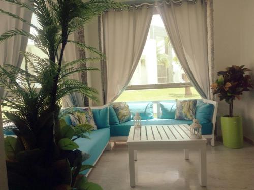 a living room with a blue couch and a table at Hivernage Founty in Agadir