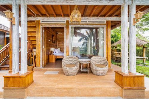 a porch of a house with a table and chairs at Peraja Bungalows Loyok in Sangyang