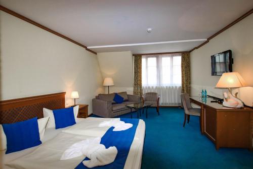 a hotel room with a bed and a living room at Gasthaus Zum Schwan in Oschatz