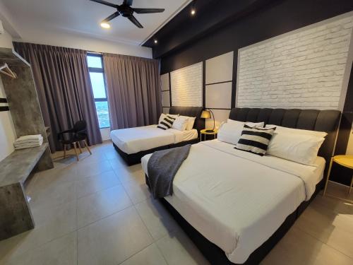 een hotelkamer met 2 bedden en een plafondventilator bij Atlantis Residences By 360 HOME in Melaka