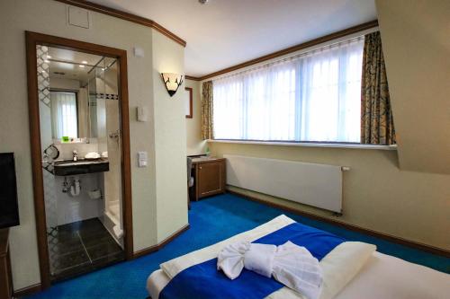 a hotel room with a bed with a bow tie on it at Gasthaus Zum Schwan in Oschatz