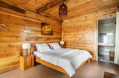 a bedroom with a bed in a wooden cabin at Peraja Bungalows Loyok in Sangyang