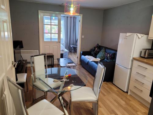 a kitchen and living room with a glass table and chairs at RentUnique Central Caledonian house cosy home in Crawley