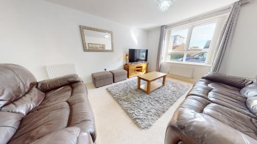 a living room with two leather couches and a television at Sparrowbill House by Cliftonvalley Apartments in Bristol