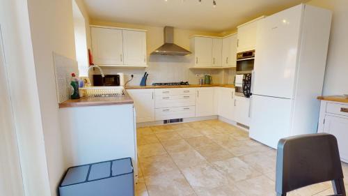 a kitchen with white cabinets and a white refrigerator at Sparrowbill House by Cliftonvalley Apartments in Bristol
