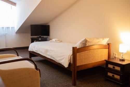 a small bedroom with a bed and a tv at Hotel Jaśmin 