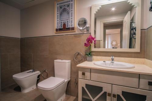 a bathroom with a toilet and a sink and a mirror at Apartamentos Turísticos La Baílla in Rota
