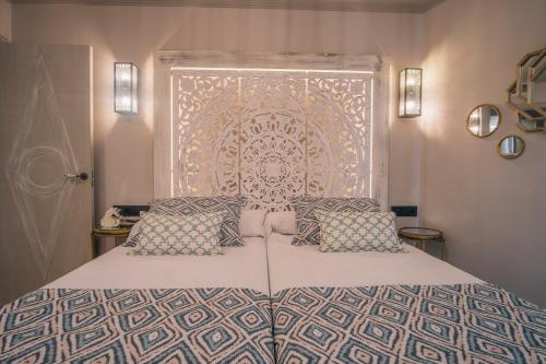 a bedroom with a bed with a large headboard at Apartamentos Turísticos La Baílla in Rota