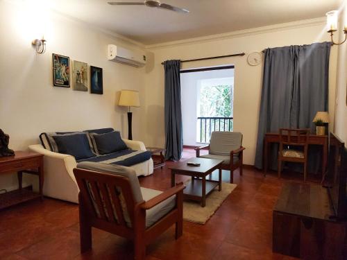 uma sala de estar com um sofá e uma mesa em Susegad Suites Goa Apartments & Villas Riviera Hermitage Arpora em Arpora