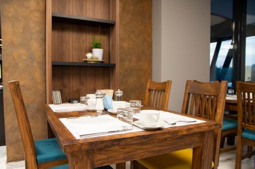 drewniany stół z krzesłami i jadalnia w obiekcie Hotel Biga w mieście Zavidovići