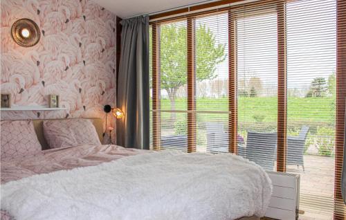 een slaapkamer met een wit bed en een groot raam bij Cozy Home In Bunschoten-spakenbu With Kitchen in Spakenburg