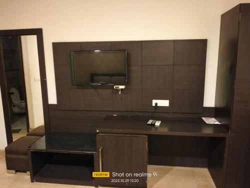 um quarto com uma televisão de ecrã plano na parede em Ashoka Hotel By WB Inn em Alwar