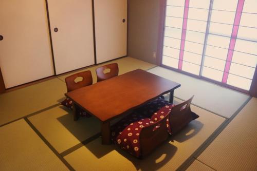a dining room with a table and two chairs at はこにわ｜田舎暮らしが体験できる宿 in Kushimoto