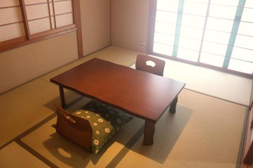 a small table and a chair with a laptop on it at はこにわ｜田舎暮らしが体験できる宿 in Kushimoto