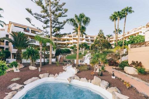 un resort con piscina e palme di Apartamento Albatros Golf del Sur Apt 257 a San Miguel de Abona