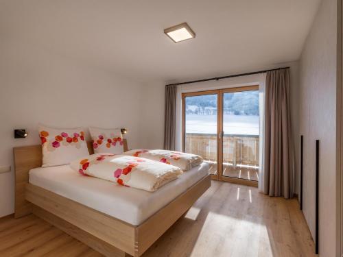 een slaapkamer met een bed en een groot raam bij Haus Seisl in Söll