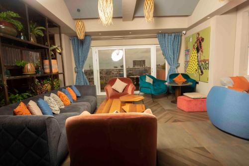 sala de estar con sofás, sillas y mesa en Roots Apartment Hotel, en Accra