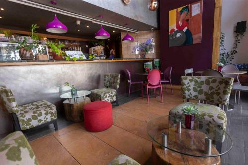 un restaurante con mesas y sillas y un bar en Roots Apartment Hotel, en Accra
