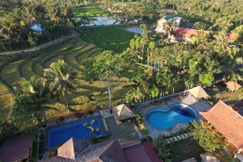 an aerial view of a resort with a pool and a golf course at Peraja Bungalows Loyok in Sangyang