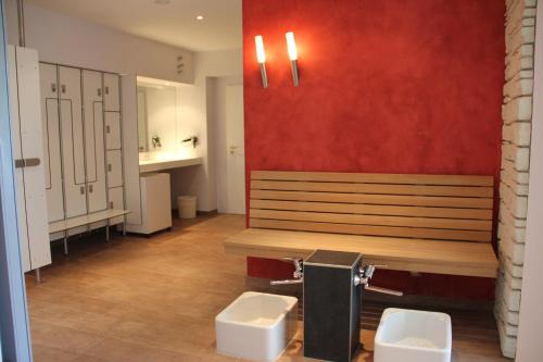 a bathroom with a bench and two toilets at Hotel Villa Dürkopp in Bad Salzuflen