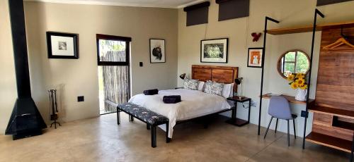 1 dormitorio con 1 cama grande y chimenea en Graceland Eco Retreat en Magoebaskloof