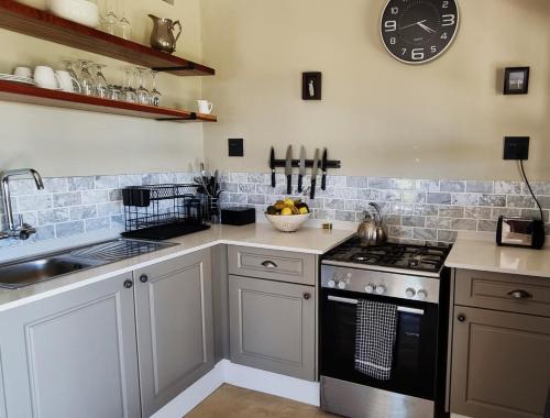 a kitchen with a stove and a clock on the wall at Graceland Eco Retreat in Magoebaskloof
