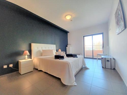 ポルティマンにあるParaiso Sol Rocha Fantastic Beach Apartmentのベッドルーム(白いベッド1台、大きな窓付)