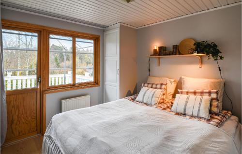 1 dormitorio con 1 cama blanca y ventana en 2 Bedroom Awesome Home In Brastad, en Brastad