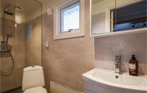 baño con aseo y lavabo y ventana en 2 Bedroom Awesome Home In Brastad, en Brastad