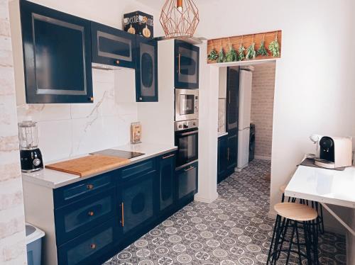 uma cozinha com armários azuis e uma bancada em Irziana - Au jardin d'Henriville em Amiens