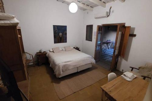 Un dormitorio con una cama y una mesa. en Casa Vieytes en San Antonio de Areco
